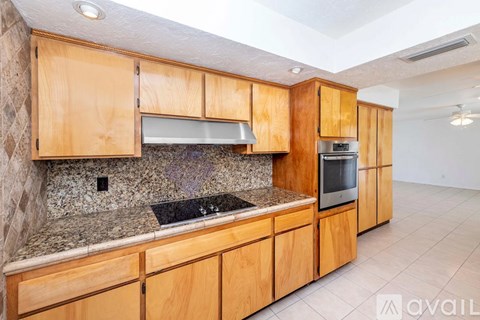 A kitchen with wooden cabinets and a granite countertop.