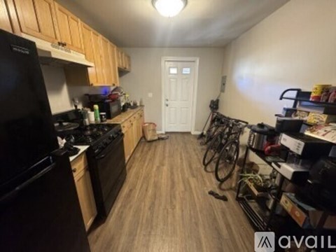 A kitchen with a black fridge and a black stove top oven.