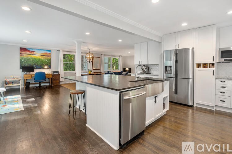 A modern kitchen with a large island and stainless steel appliances.