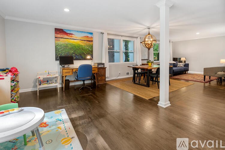 A living room with a white ceiling and a painting on the wall.