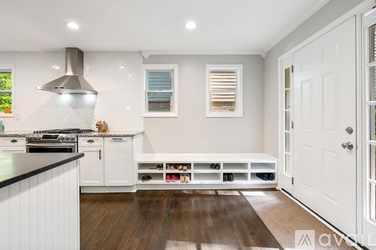 A modern kitchen with white cabinets and a black countertop.