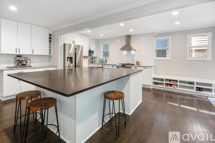 A modern kitchen with a large island and bar stools.