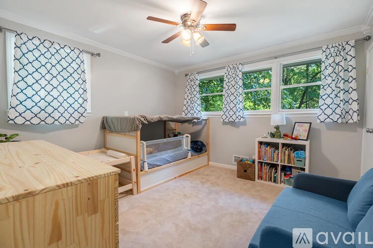 A room with a bed, a couch, and a ceiling fan.