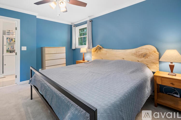 A bedroom with blue walls and a large bed.