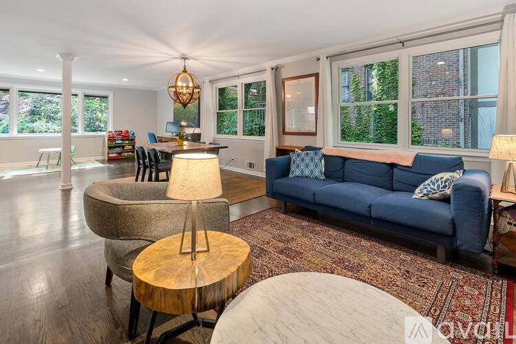 A living room with a blue couch and a wooden table.