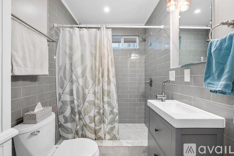 A bathroom with a white toilet, a white sink, and a shower curtain.