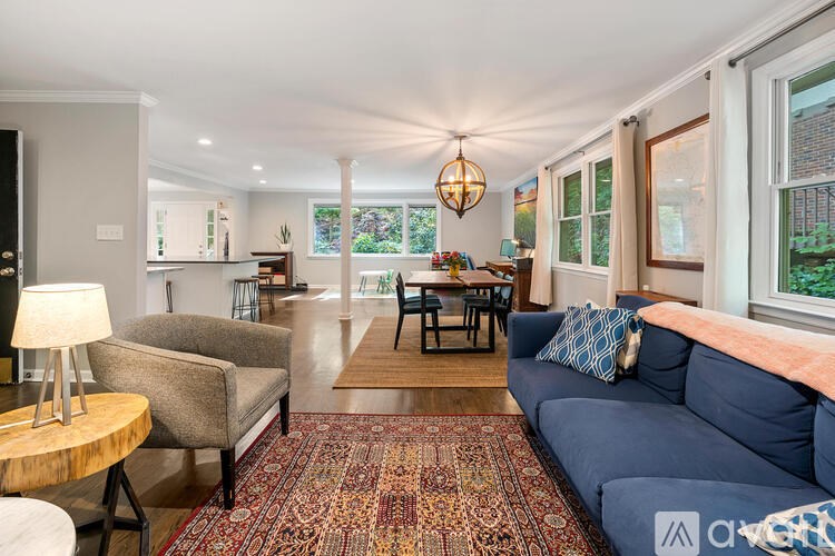 A living room with a blue couch and a rug.
