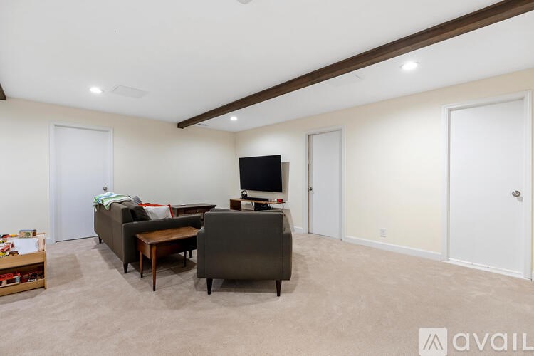 A living room with a couch, chair, and television.