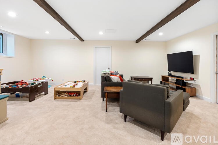 A living room with a grey couch and a television on a stand.