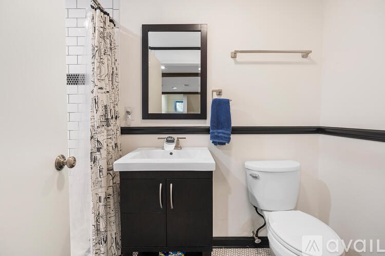 A bathroom with a toilet, sink, and mirror.