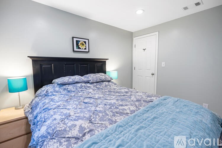 A bedroom with a bed covered in a blue and white patterned duvet.