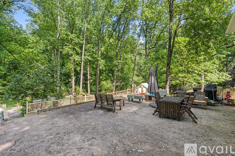 A backyard with a picnic table surrounded by trees.