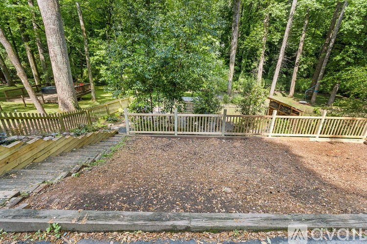 A backyard with a wooden fence and a gravel area.