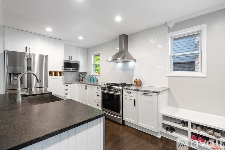 A modern kitchen with white cabinets and a black countertop.