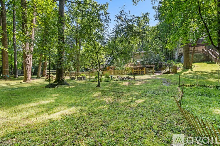 A lush green park with trees and a wooden bench.