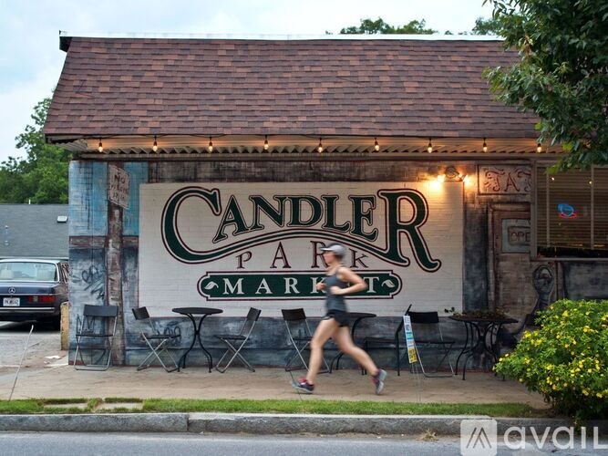 A woman runs past a building with a sign that says Candler Park Market.