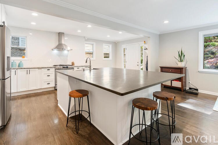 A modern kitchen with a large island and stools.