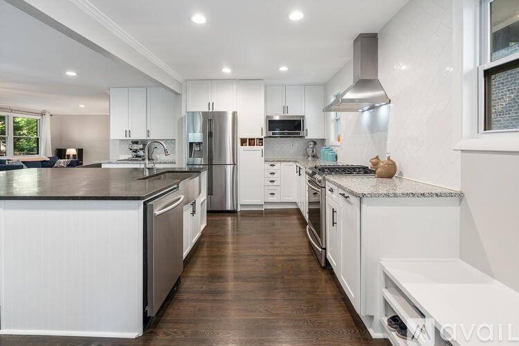 A modern kitchen with white cabinets and stainless steel appliances.