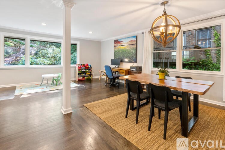 A dining room with a wooden table and chairs.
