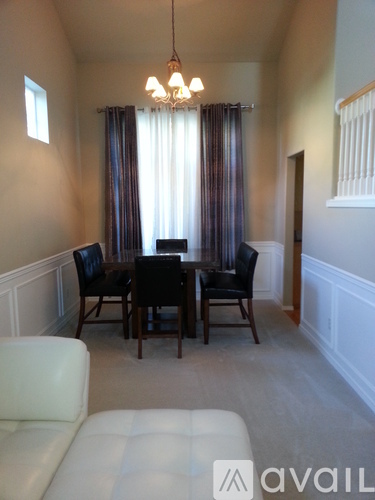 A dining room with a table and chairs.
