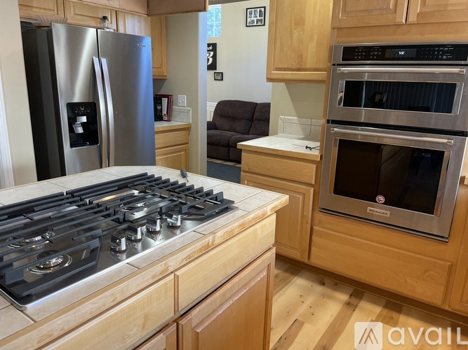 A kitchen with a stove top oven and a refrigerator.