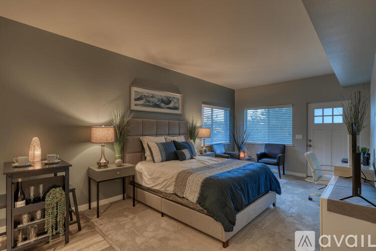 A bedroom with a large bed and a painting on the wall.