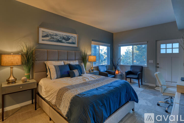 A bedroom with a large bed and a painting on the wall.
