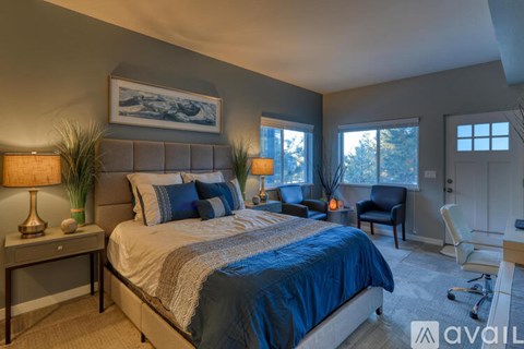 A bedroom with a large bed and a painting on the wall.