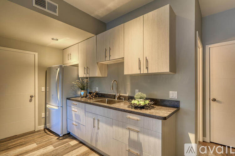 A kitchen with a refrigerator, cabinets, and a countertop.