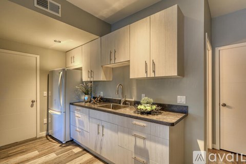 A kitchen with a refrigerator, cabinets, and a countertop.