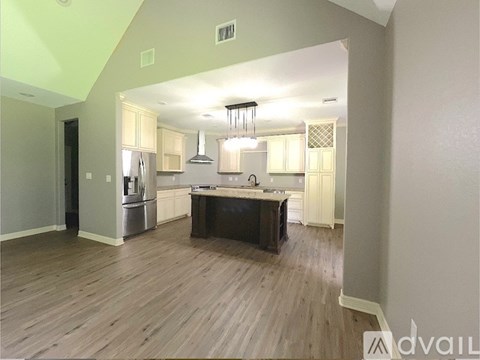 A kitchen with wooden floors and a large island in the middle.