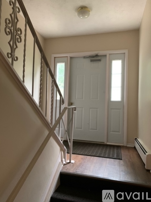 A staircase with a metal railing and a white door at the bottom.