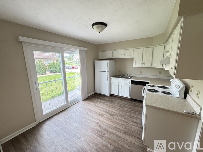 A kitchen with white appliances and cabinets is available for rent.