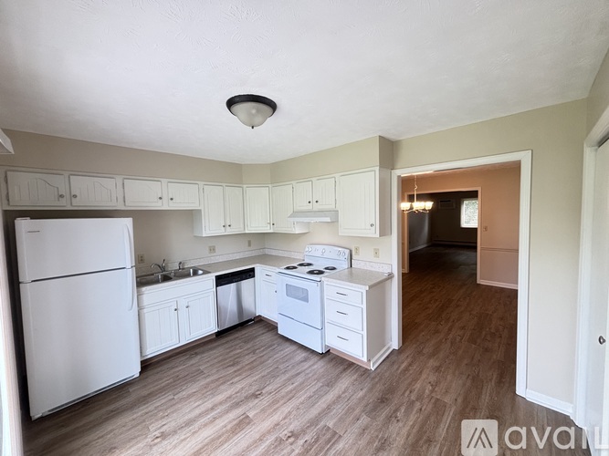 A kitchen with white appliances and cabinets.
