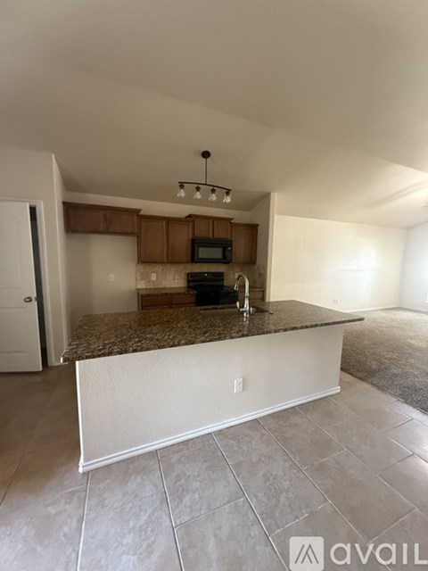 A kitchen with a granite countertop and a microwave.