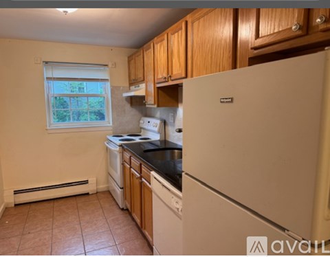 A kitchen with wooden cabinets and a white refrigerator.