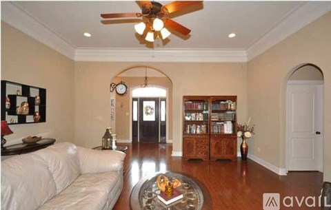 A living room with a white couch and a ceiling fan.
