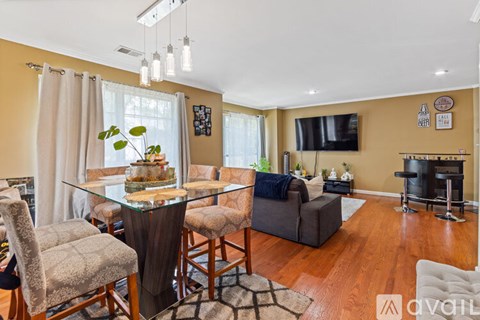 A modern living room with a glass dining table and chairs.