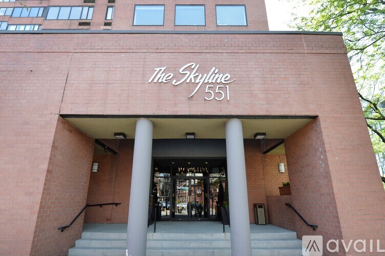 The front of a building with the name "The Skyline" and the number 551 on it.