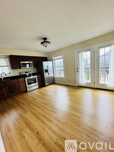A kitchen with wooden floors and a refrigerator.