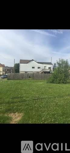 A white house with a brown fence in front of it.