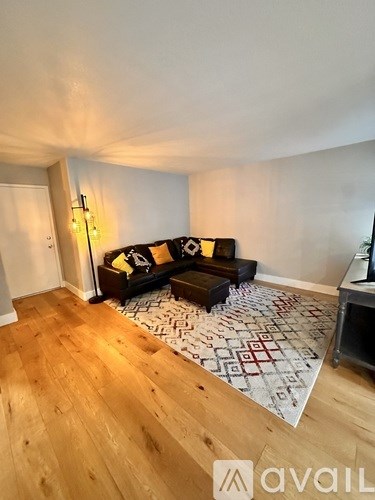 A living room with a couch and a rug.