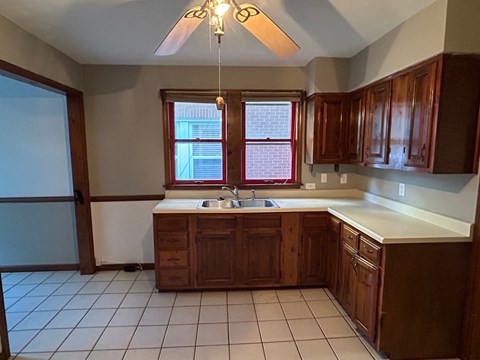 A kitchen with brown cabinets and a white counter.