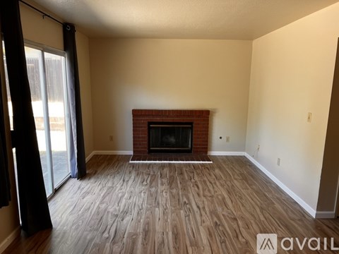 A living room with a fireplace and wooden flooring.