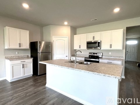 A kitchen with white cabinets and a granite countertop.
