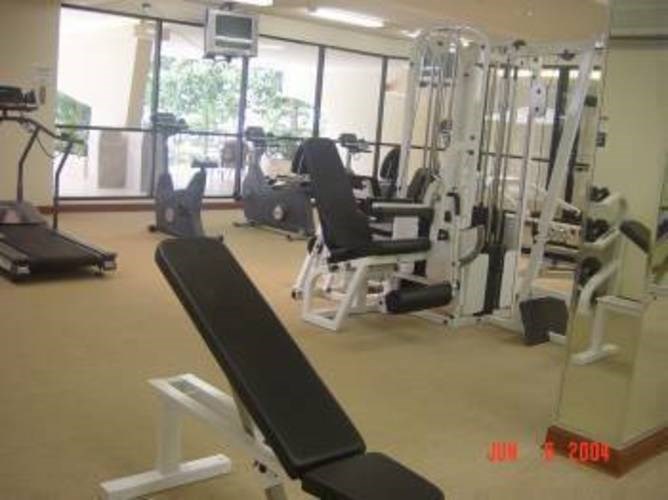A gym with a variety of equipment including weights and a treadmill.
