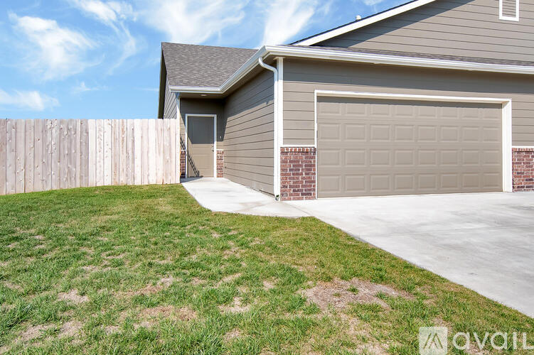 A house with a grey garage door and a wooden fence.