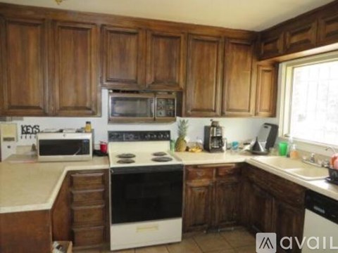 A kitchen with wooden cabinets and white appliances.