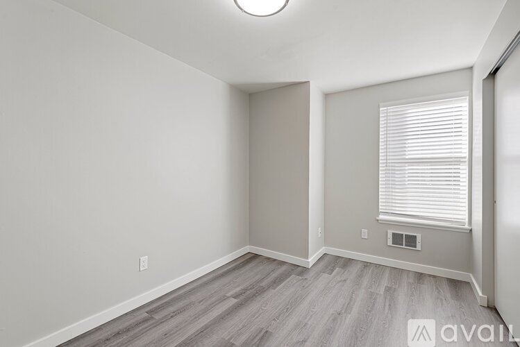 A room with a window and a wooden floor.