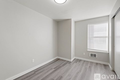 A room with a window and a wooden floor.